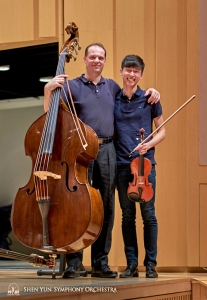 低音大提琴首席優瑞•庫坎和小提琴演奏員奧斯汀對著鏡頭露出燦爛的笑臉。